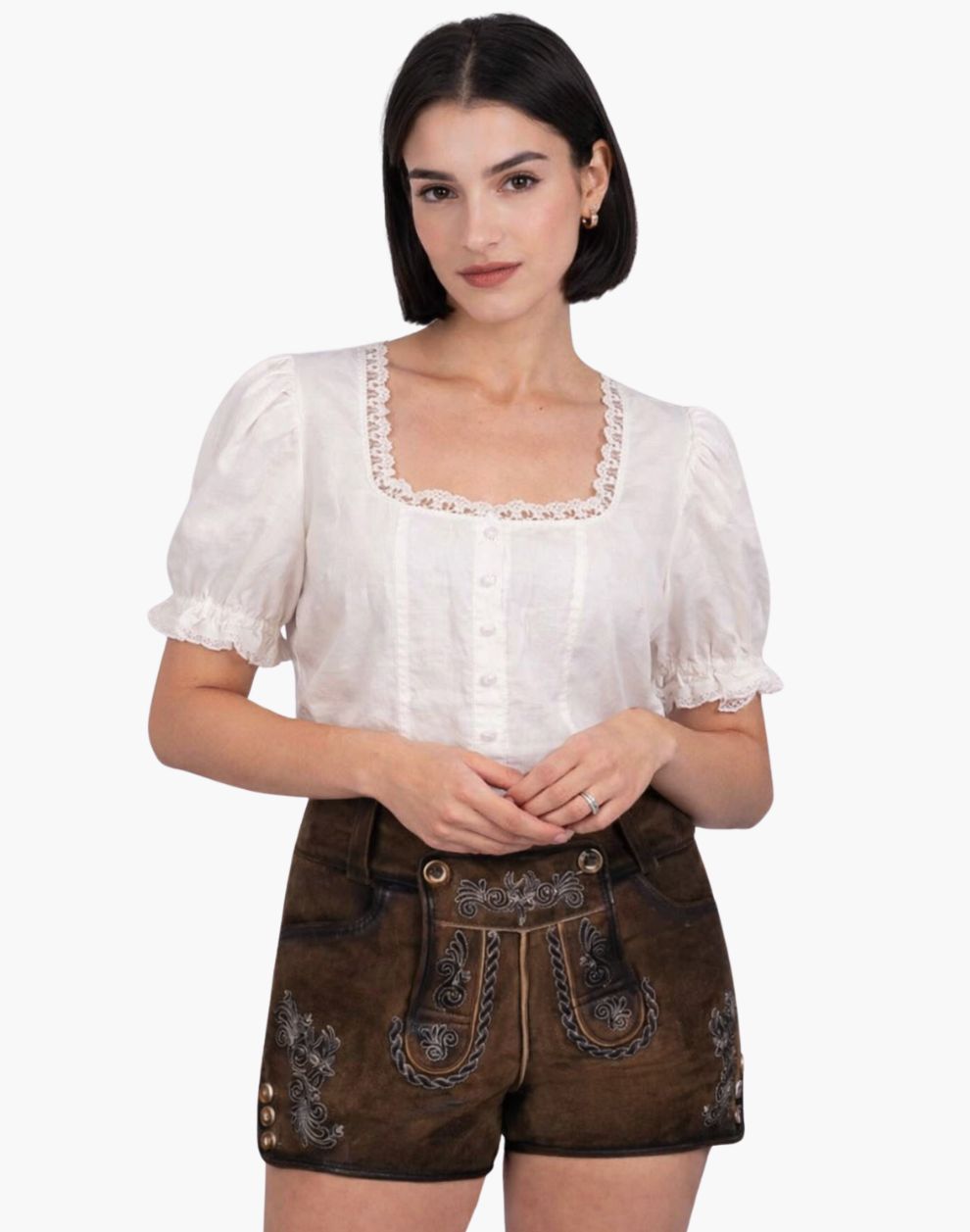 Woman wearing a white blouse with lace details and brown traditional shorts on a white background