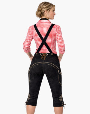 Woman wearing a traditional Bavarian outfit with black pants and red checkered shirt on a white background