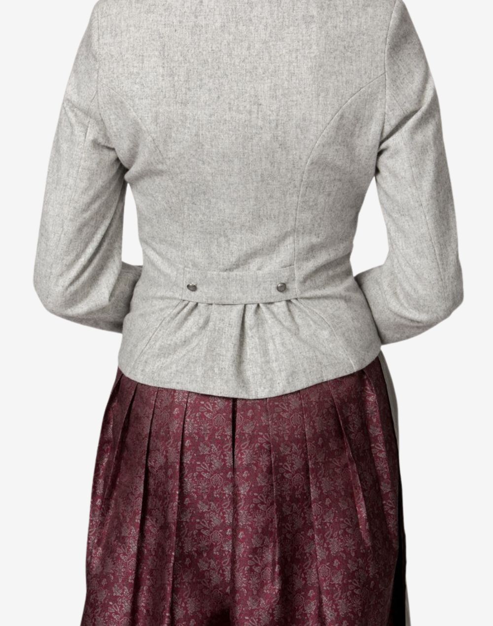 Close-up back view of a women’s light grey traditional Bavarian trachten jacket featuring a fitted waist with pleated back detail, worn over a burgundy patterned dirndl skirt.