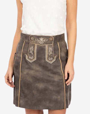 Women’s vintage-style brown leather trachten skirt with embroidered front panel, decorative stitching, and traditional Bavarian design, shown worn with a white blouse.
