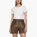 Woman wearing a white t-shirt and brown embroidered Lederhosenson a white background