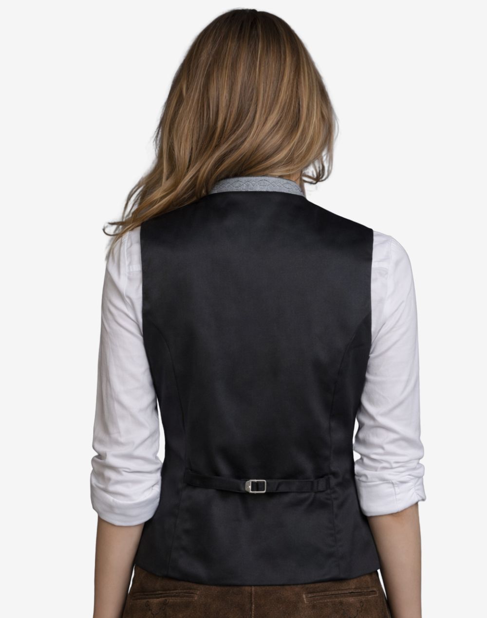 Person wearing a black vest over a white shirt on a plain background