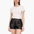 Woman wearing a white t-shirt and black leather shorts on a white background