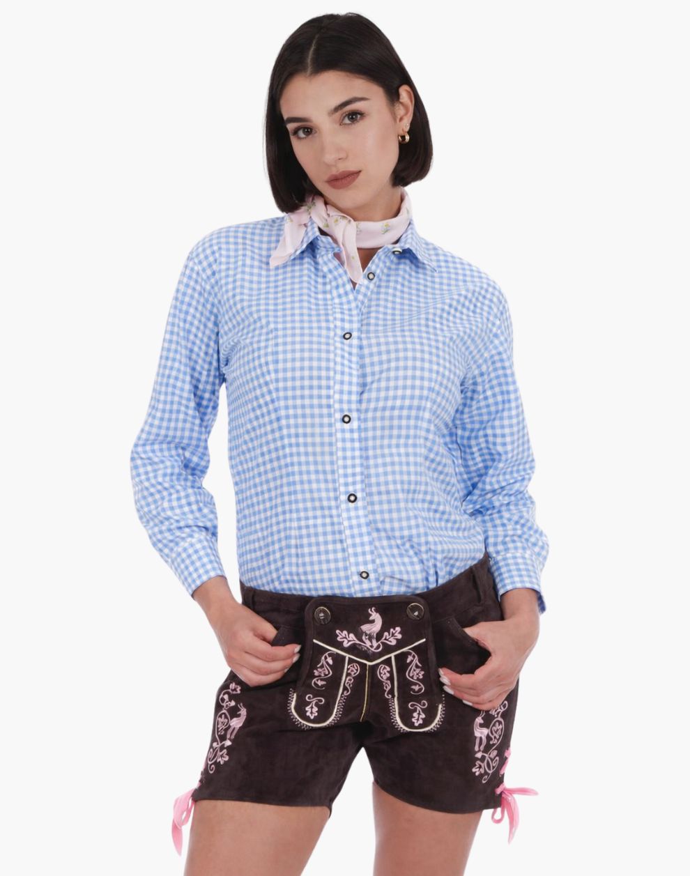 Woman wearing embroidered brown leather lederhosen shorts with a blue gingham shirt and a light pink neck scarf, styled in traditional Bavarian Oktoberfest fashion.