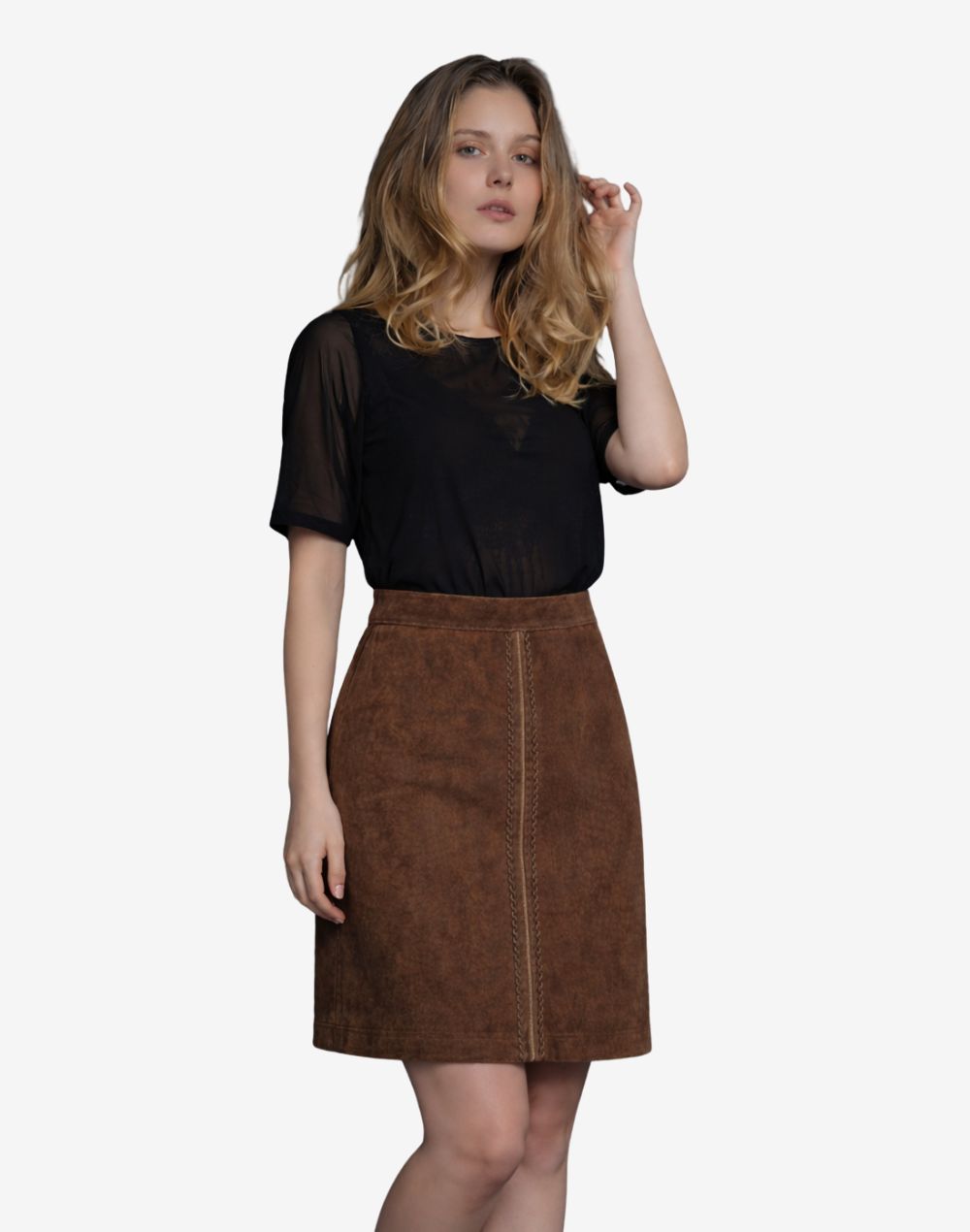 Front view of women's rustic brown high-waisted suede Trachten skirt with A-line silhouette and decorative braided front seam, paired with a sheer black short-sleeve top.