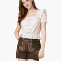 Woman wearing a white blouse and brown shorts with embroidery on a white background