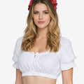 Front view of a woman wearing a white dirndl-style cropped blouse with short puff sleeves, elastic hem, and ruffled neckline, paired with a red floral headband.