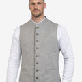 Man wearing a gray vest over a white shirt on a white background
