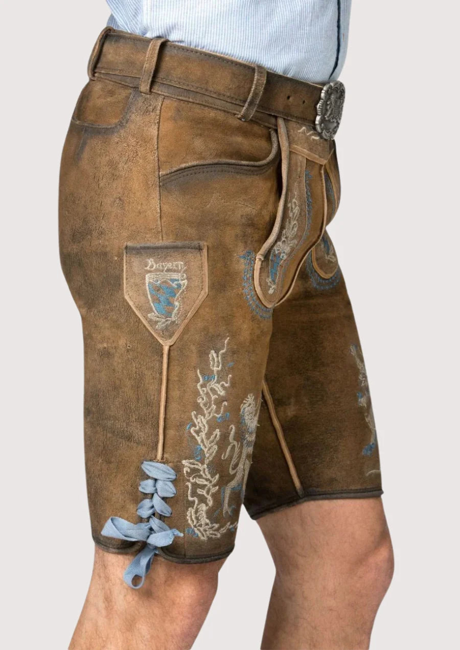 Side view of men’s brown leather lederhosen with traditional Bavarian embroidery and lace ties