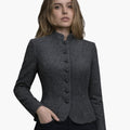Woman wearing a gray blazer with black buttons on a white background